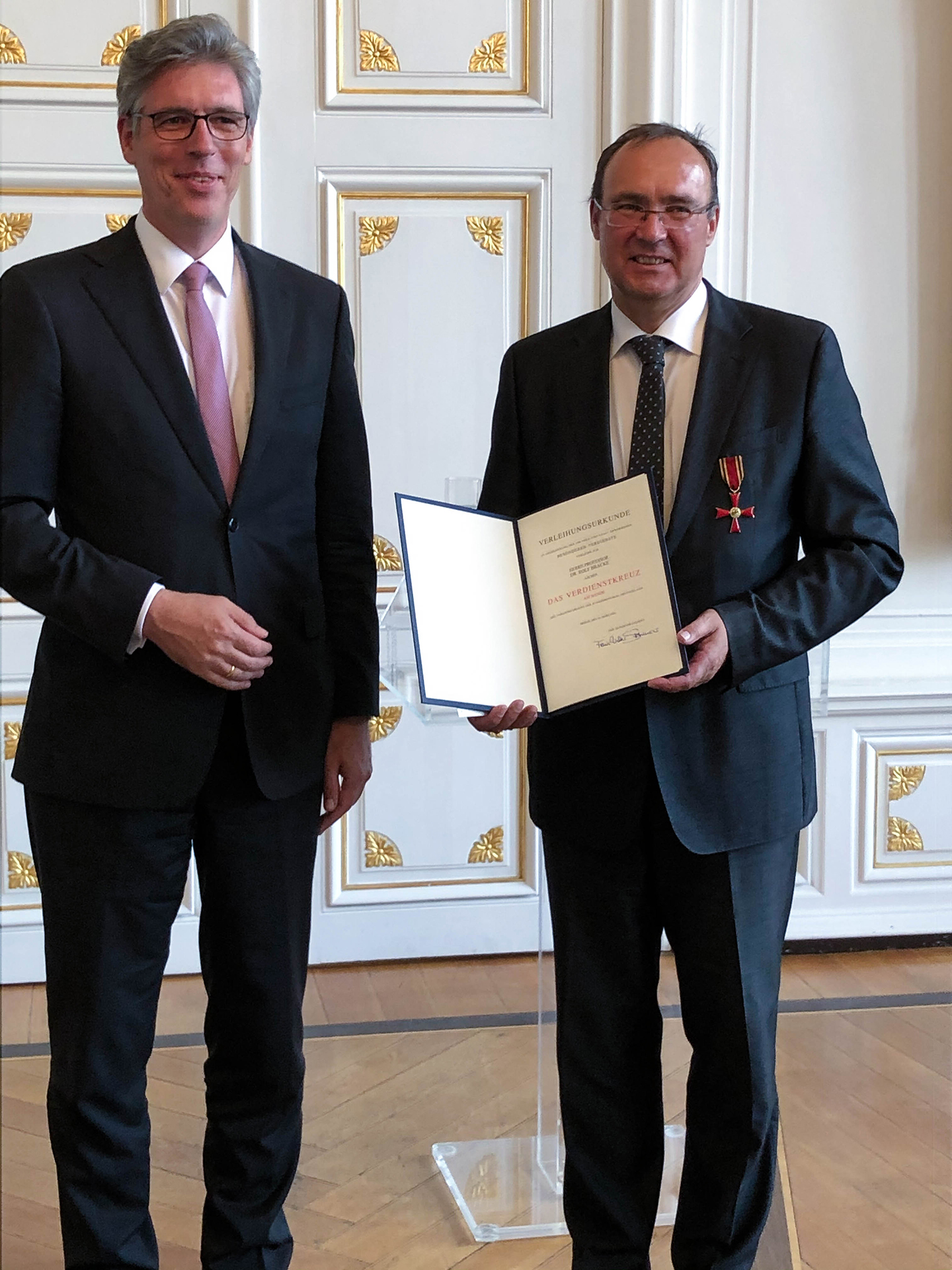 Prof. Rolf Bracke (re.) erhält das Bundesverdienstkreuz, hier mit Marcel Philipp (li.), Oberbürgermeister der Stadt Aachen. 
