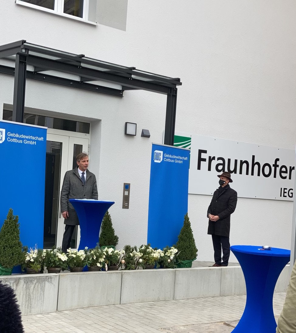Mario Ragwitz (l.), Leiter des Fraunhofer IEG, begrüßt unter freiem Himmel Oberbürgermeister Holger Kelch, Gäste und Medienvertreter am neuen Cottbuser Standort. 